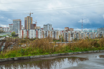 Fototapeta premium Городской пейзаж с жилыми домами и асфальтированной дорогой