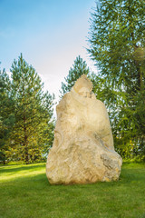 Каменная скульптура стоит в парке