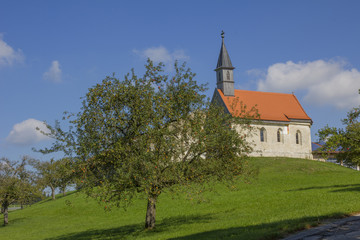 Dorfkapelle mit Obstgarten, Apfelbäume mit reifen Äpfeln