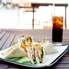 Club sandwich with iced soda drink