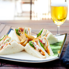 Club sandwich with french fries and a beer