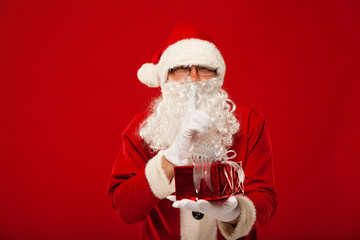 Photo of kind Santa Claus giving xmas present and looking at