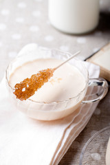 Glass cup with yogurt and cane sugar crystals