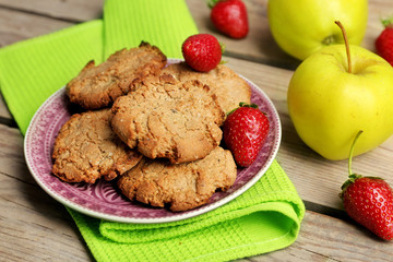 Homemade cookies with strawberries and apples on table close up