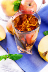 Glass of apple juice with fruits and fresh mint on table close up