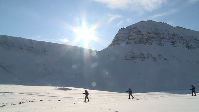 Group of tourists skiing in the far north, surrounded by the snow-covered hills.