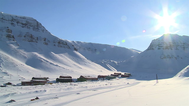 Small town Longyearbyen among snow-capped mountains of the Norwegian archipelago of Svalbard in early spring.