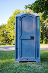 Siingle Blue Outhouse on Grass in Park