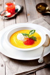 Pumpkin soup with cream and red salmon caviar