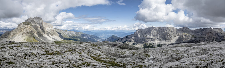 Panorama estivo di alta montagna in largo formato con montagne, rocce e cielo