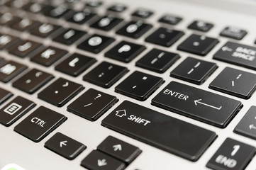 Laptop computer keyboard close up with red enter key button