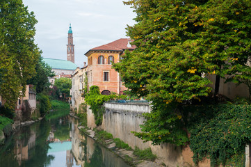 Fototapeta na wymiar View of Retrone river and the clock tower of Vicenza, Italy, seen from Furo bridge