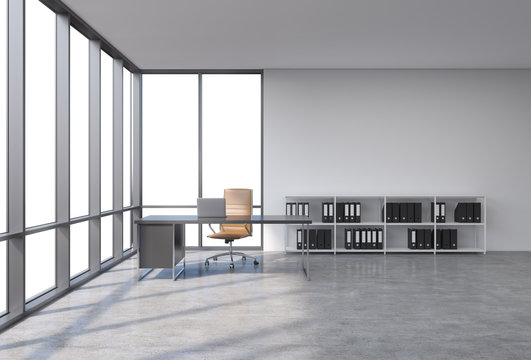 A workplace in a modern corner panoramic office with copy space in the windows. A black desk with a laptop, brown leather chair and a bookshelf with black document folders. 3D rendering.