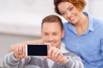 Pleasant couple sitting in the armchair 