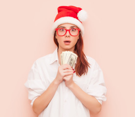 woman in Santa Claus hat with money