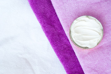 white cream  in a bowl on pink textured towel background - studi