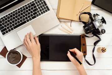 Designer using graphic tablet in work, photo editing from above