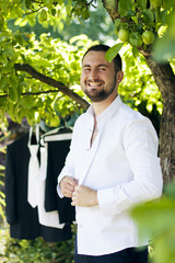 Happy groom preparing himself for wedding.