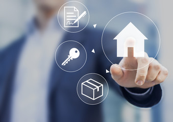 Hand pushing house button on screen with mortgage contract, keys