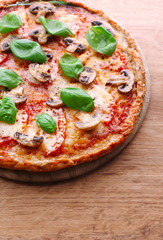 Tasty pizza with vegetables and basil on table close up