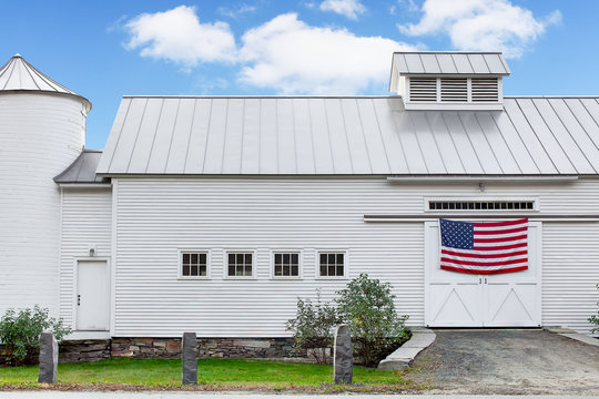White barn with American flag on the door