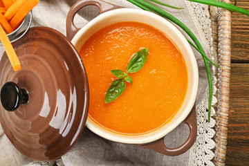 Carrot cream-soup with vegetables on table close up