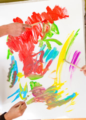 Naklejka premium People painting with paintbrushes and paints on canvas