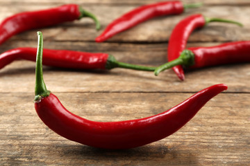 Red hot peppers on wooden table close up