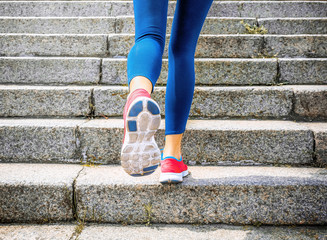 Fototapeta na wymiar Young woman jogging at stairs outdoors