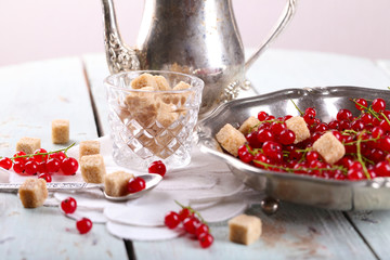 Fresh red currants with sugar on table close up