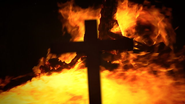 Cross silhouette fire pyre strong wind