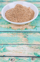 Lemongrass powder in a white bowl over wooden background