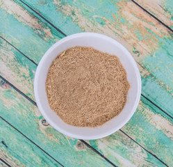 Lemongrass powder in a white bowl over wooden background