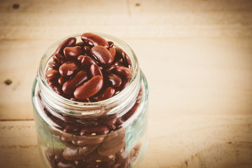 red  beans on wood background - soft focus with vintage film fil