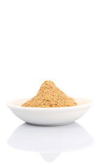 Dried lemongrass powder in a white bowl over white background
