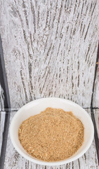 Lemongrass powder in a white bowl over wooden background