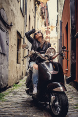Obraz na płótnie Canvas Awesome casual woman posing with moto scoote.