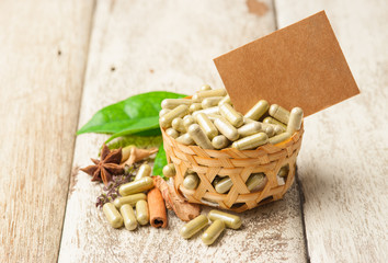 Herb capsule with green herbal leaf on wood,paper note for text