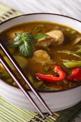 Soup green curry chicken macro on the table and chopsticks. vertical
