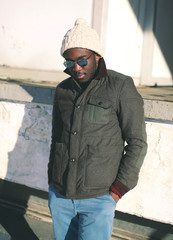 Naklejka premium Fashion stylish young african man wearing a sunglasses and jacke