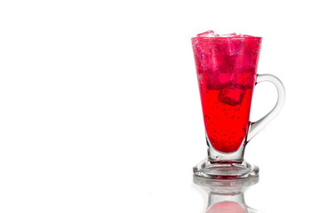 Refreshing red fizzy soft drink with ice in transparent glass