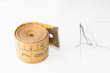 Thimble, needle, tape measure