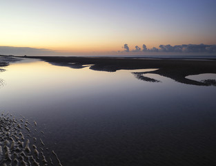 Beautiful tranquil sunrise over low tide beach