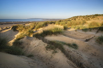 Beautiful sunrise over sand dunes system on yellow sand golden b