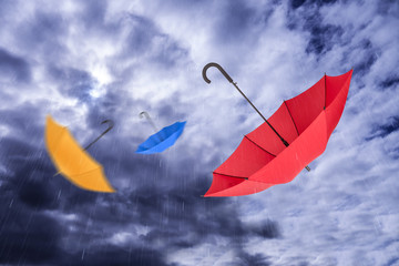 Fliegende Regenschirme im Regenhimmel