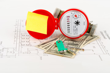 Red water meter with cash and keys on draft