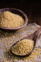 Raw Bulgur (on wooden background)
