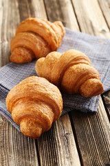 Tasty croissants on brown wooden background