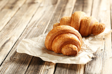 Tasty croissants on brown wooden background