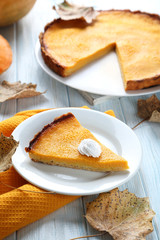 Tasty pumpkin pie on plate on a blue wooden table